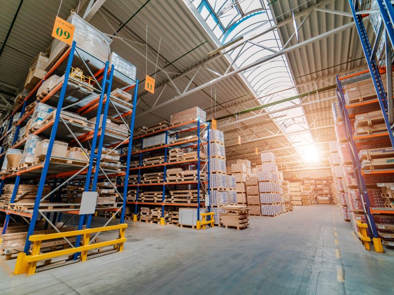 Warehouse storage of a retail goods store. Rows of shelves with boxes